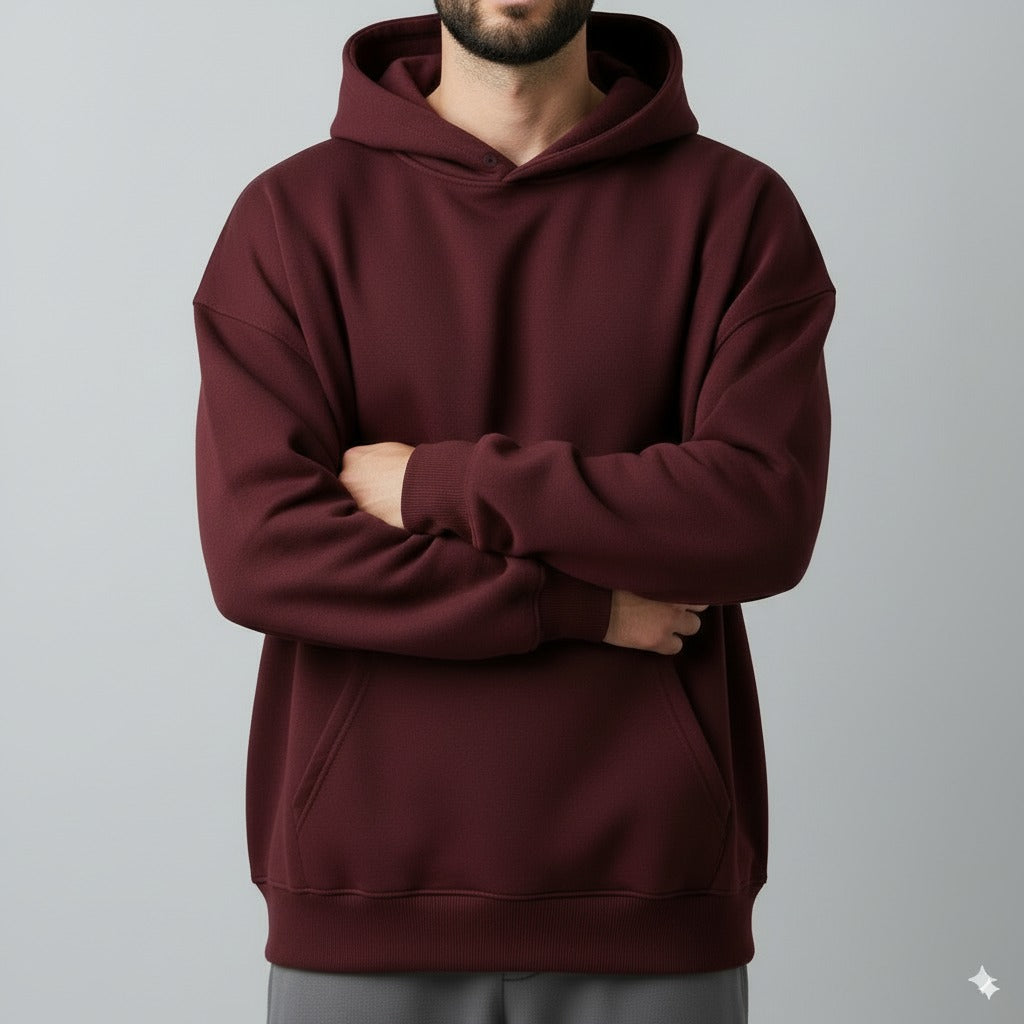 burgundy hoodie worn by a person on a gray background