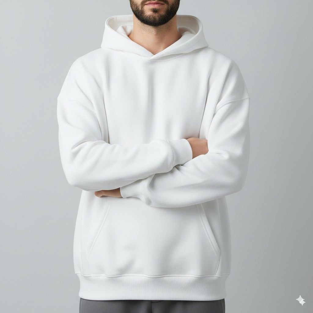 Person wearing a white hoodie with arms crossed on a gray background