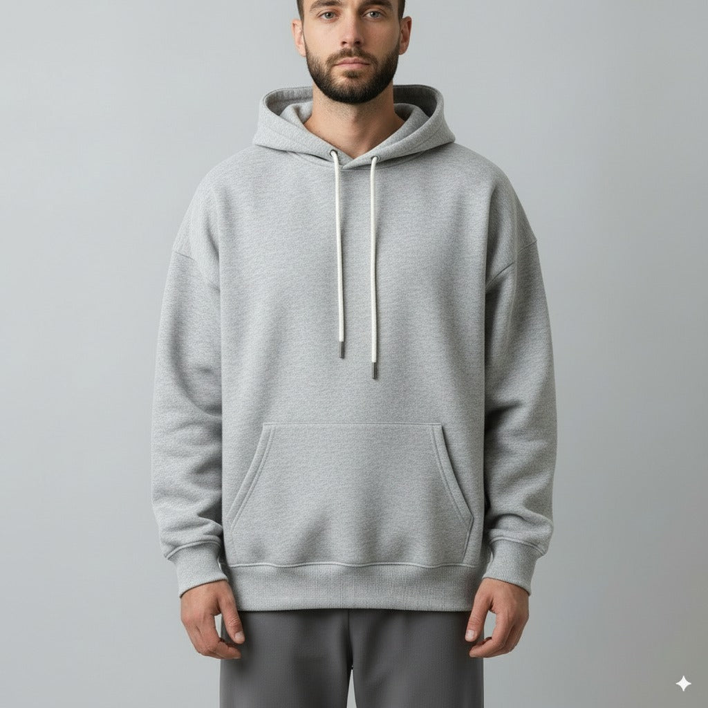 Man wearing a gray hoodie on a plain background